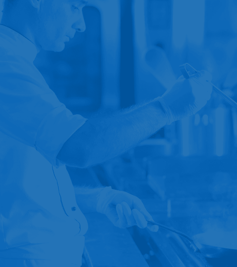 Blue tone on tone image of professional chef cooking on a stove